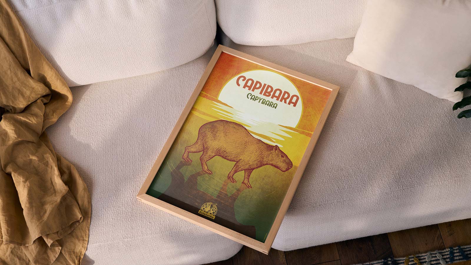 Ein gerahmtes Poster eines Capybaras liegend auf einem Sofa